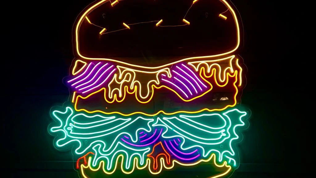 The Galaxy Burger on a sesame bun under the neon sign
