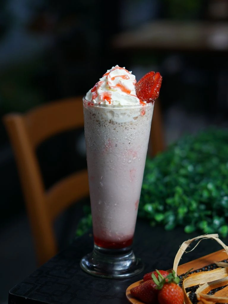 Strawberry milkshake with whipped cream and fresh berry