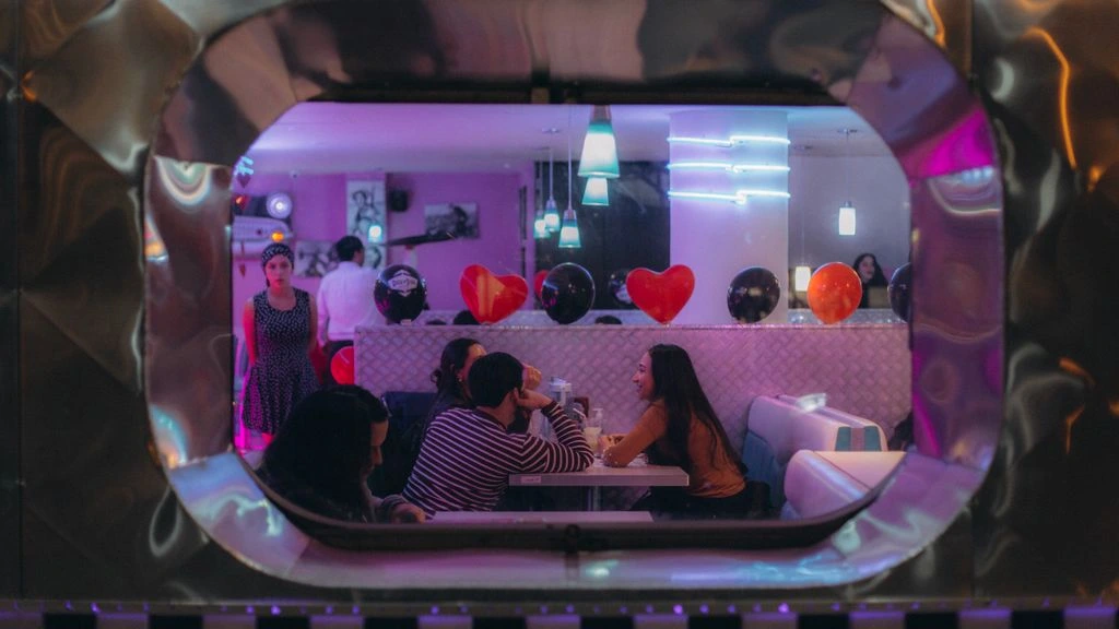 The Meteor Room dressed for a private birthday dinner under string lights and a glowing neon sign